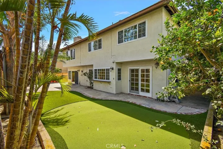 Entertain at easy-care backyard with partial artificial turf, extensively paved patio space