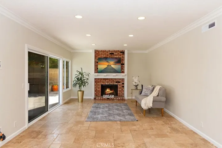 The expansive family room offers heart warming red brick fireplace with raised hearth and white wood mantle