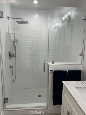 Primary shower with rain showerhead and hidden bench