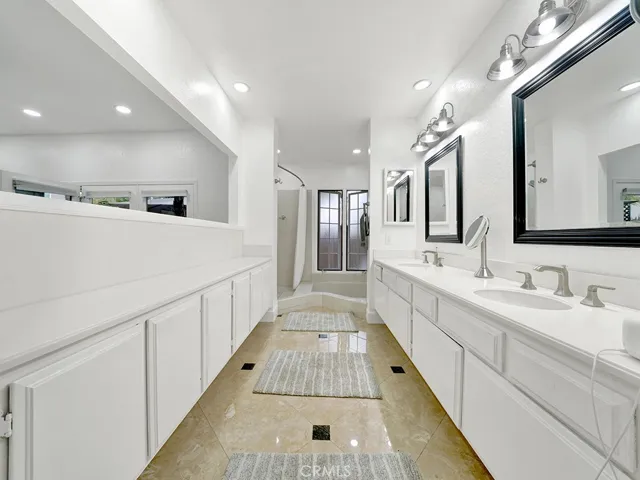 Primary bathroom with walk in shower, sunken tub, dual vanities