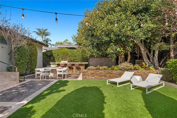 A step-down dining patio, fireplace, water wall, and a built-in BBQ bar.