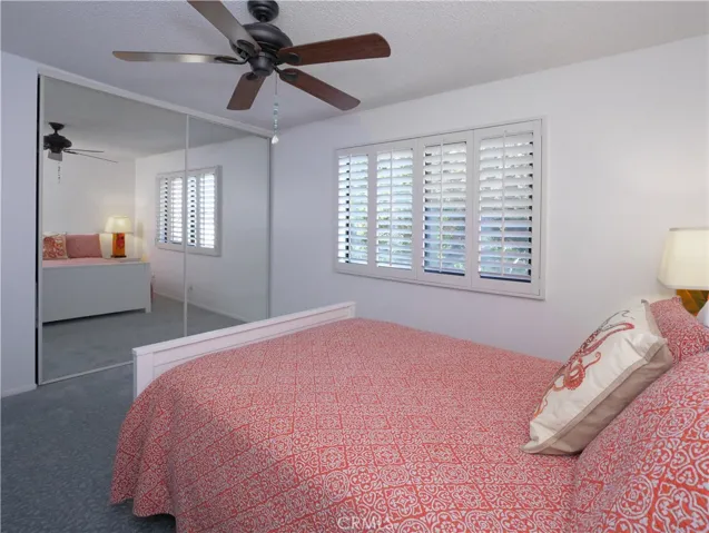 2nd Bedroom with Fan and Mirrored Closet Doors with Custom Closet Storage