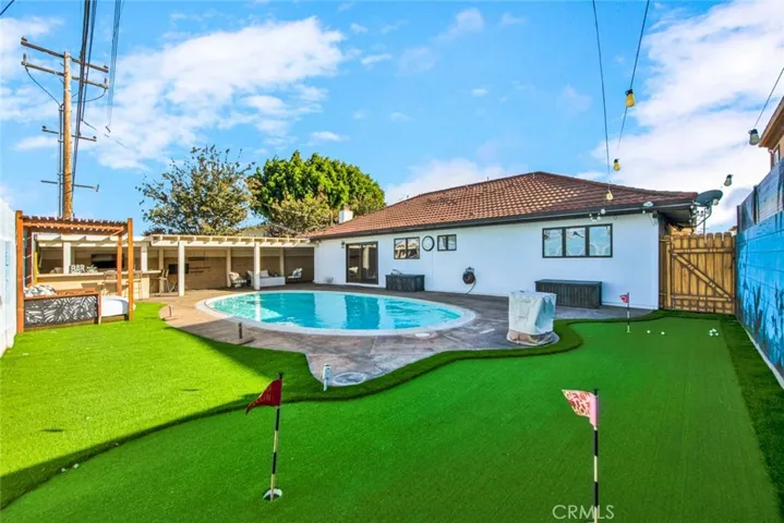Artificial grass surrounds the pool area with a 3-hole putting green