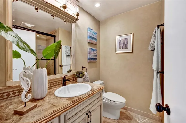 The updated guest bath features granite countertops, custom lighting.