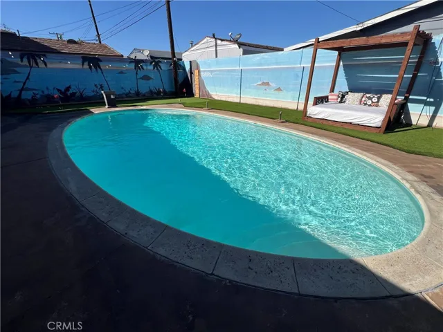 Step into your backyard oasis, where a sparkling pool, stained concrete decking