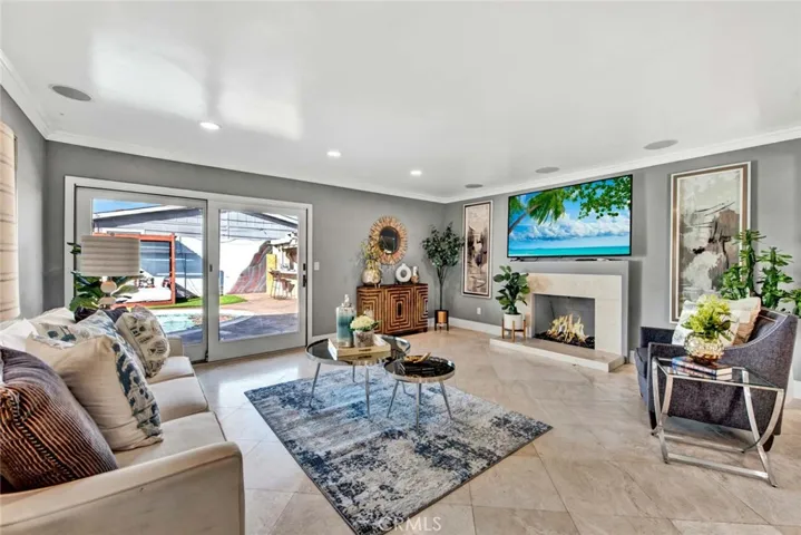 The open living area boasts a custom tiled fireplace with a raised hearth and designer glass rocks