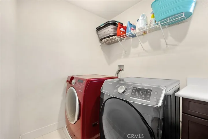 upstairs laundry room with utility sink and storage.