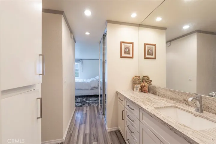 Dressing area and vanity to the full length closet and natural lighted bedroom