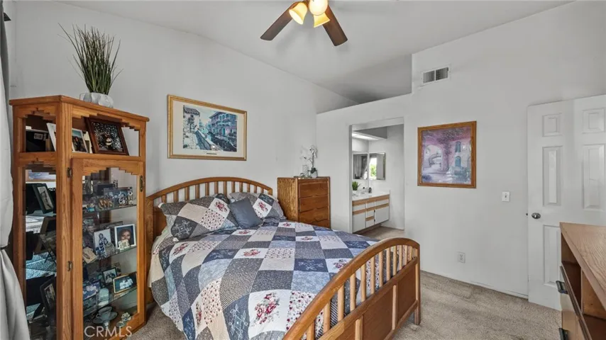 Primary bedroom with double doors, ceiling fan, vaulted ceilings and walk-in closet