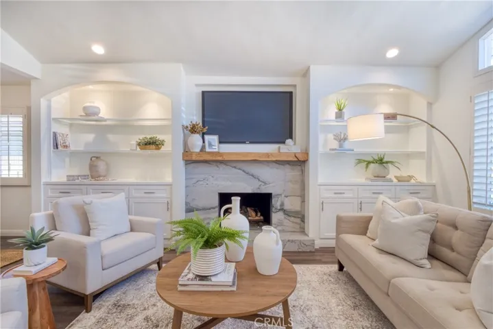 The living room's focal point is the attractive granite fireplace & hearth surrounded by custom built-in cabinetry