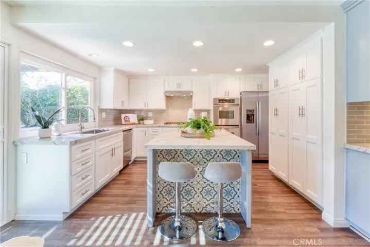 Cheerful custom "white" kitchen with center island and counter seating