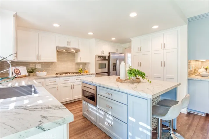 Kitchen with stainless steel appliances, including 5 burner gas cooktop & refrigerator