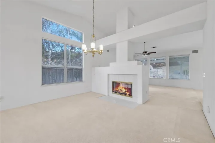 Living room and family room separated by double sided fireplace with gas log set.