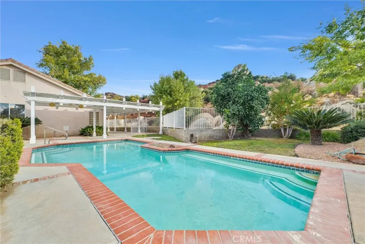 Pool with with view of foothills behind home
