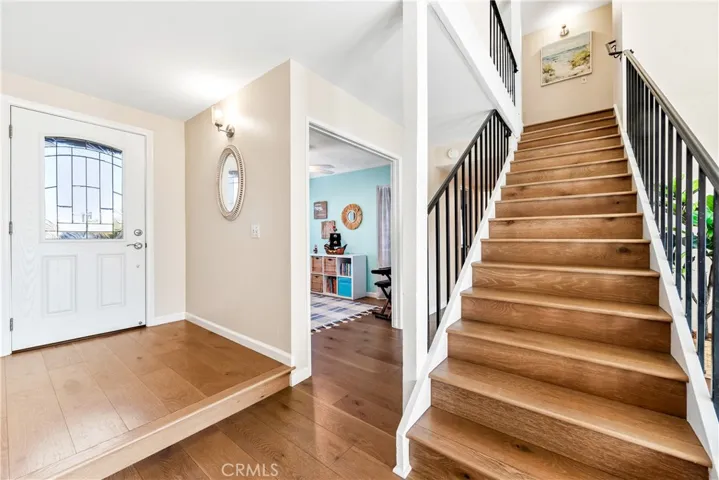 Entry door and view of stairs and bedroom 3