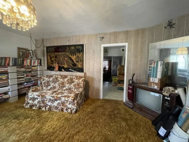 Living room, near the main entrance, leading towards the kitchen.