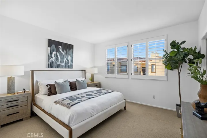 Bedroom w/ classic Plantation Shutters covering oversized windows with loads of sunlight peering through