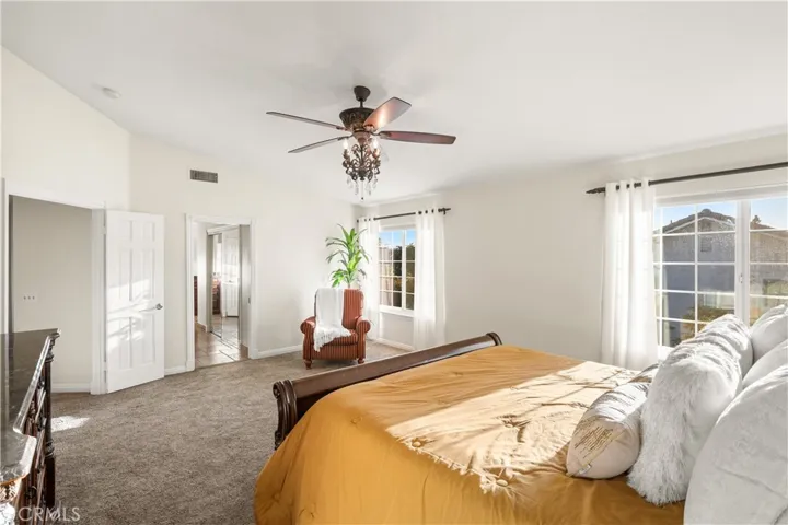 View to the double doors and entrance to the primary bathroom and walk in closet.