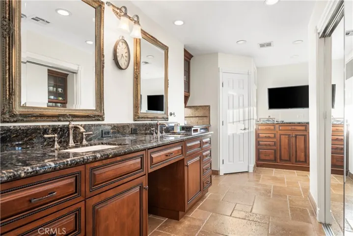 Primary bathroom with beautiful cabinetry, dual sinks and water closet (which is behind that white door)