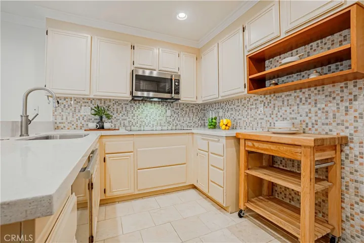 The tastefully styled kitchen features stainless steel appliances, large double ovens, induction cooktop, and it is great for entertaining, dinner parties, and ideal for everyday living with French doors that open to the backyard.