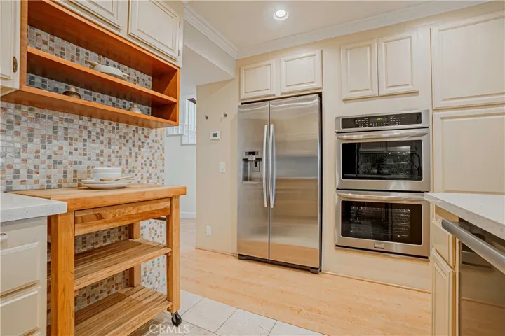 The tastefully styled kitchen features stainless steel appliances, large double ovens, induction cooktop, and it is great for entertaining, dinner parties, and ideal for everyday living with French doors that open to the backyard.