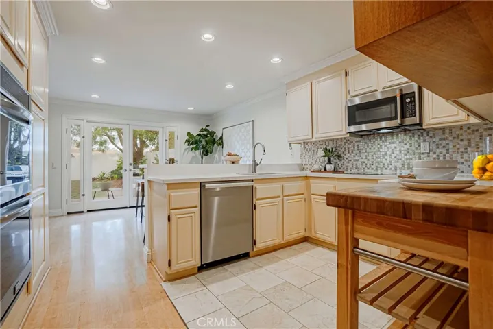 The tastefully styled kitchen features stainless steel appliances, large double ovens, induction cooktop, and it is great for entertaining, dinner parties, and ideal for everyday living with French doors that open to the backyard.