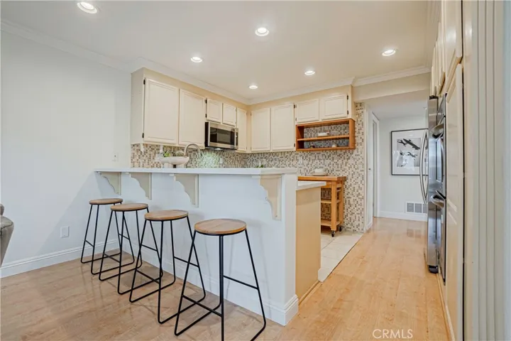 The tastefully styled kitchen features stainless steel appliances, large double ovens, induction cooktop, and it is great for entertaining, dinner parties, and ideal for everyday living with French doors that open to the backyard.