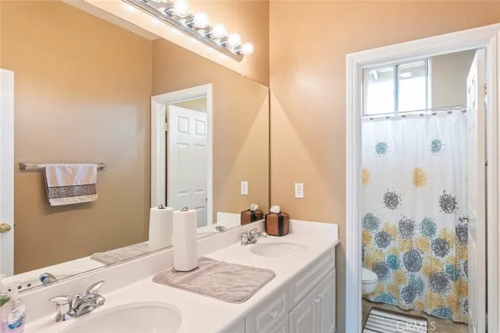 A stylish bathroom, a dual-sink vanity, a large mirror, and a separate shower area with natural light.