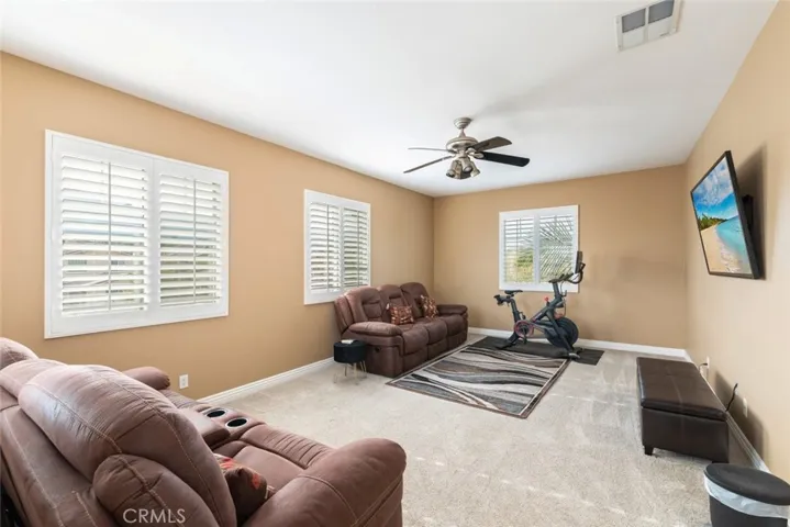 A bright and versatile room with large windows, and ample space, perfect for entertaining or relaxing.
