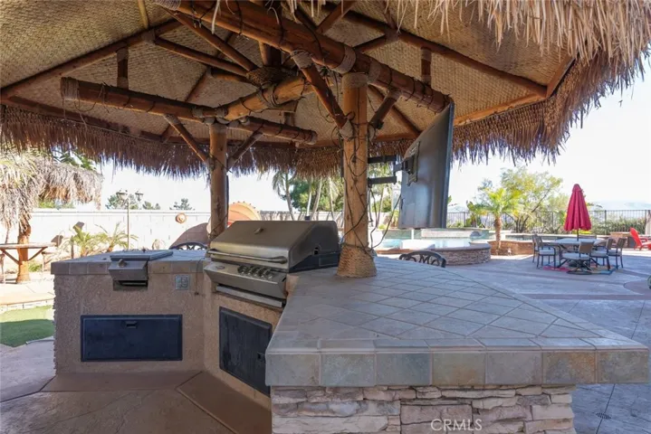 Outdoor barbecue area with a built-in grill, bar seating, perfect for hosting gatherings.