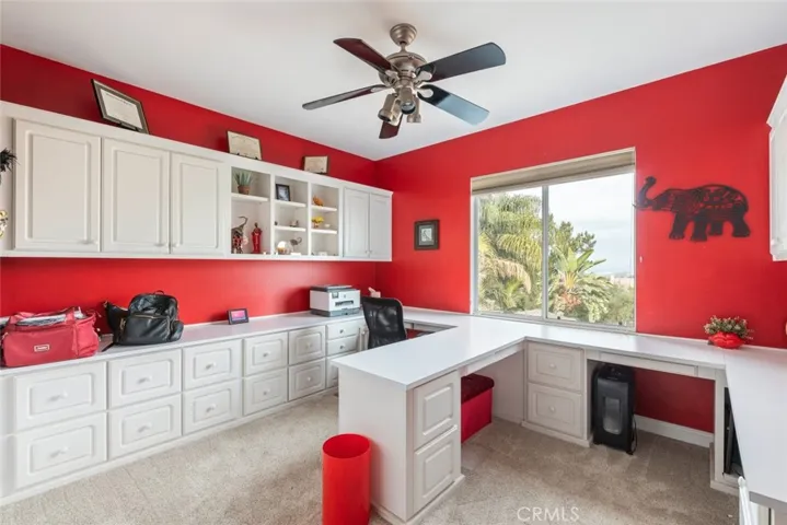 A home office with built-in cabinetry and plenty of workspace.