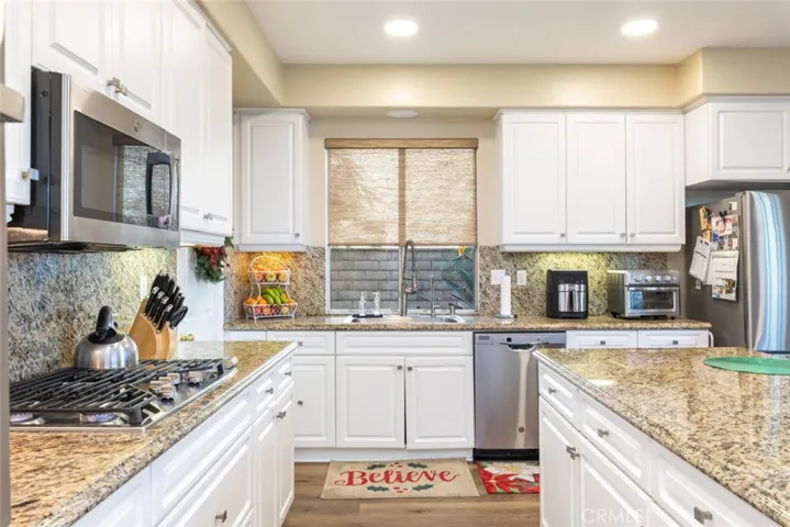 
Modern kitchen equipped with sleek stainless steel appliances, a gas cooktop, and a built-in microwave for meal preparation.