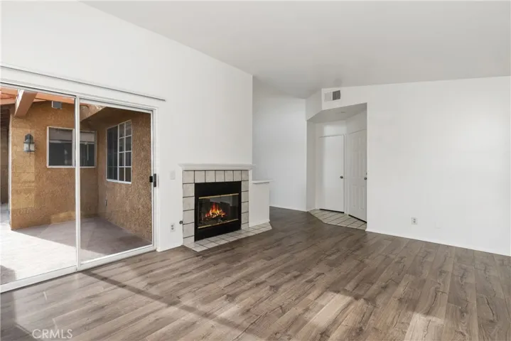 Spacious room with abundant natural light and hardwood flooring.
