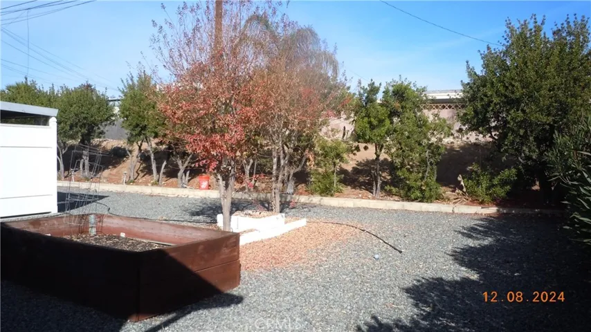 Reverse view showing the planter bed, trees and portion of the yard.