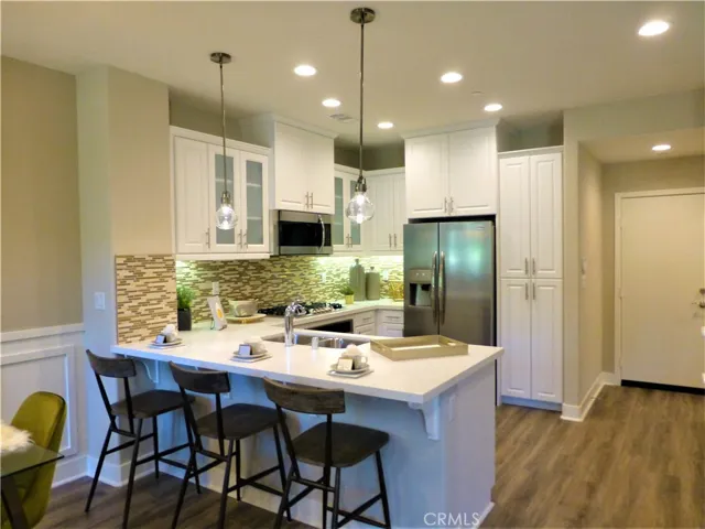 These are photos of the model home . The subject property will have beautiful light grey cabinets, upgraded laminate floors, upgraded carpet on stairs, and numerous other upgrades. There will not be any wainscoting.