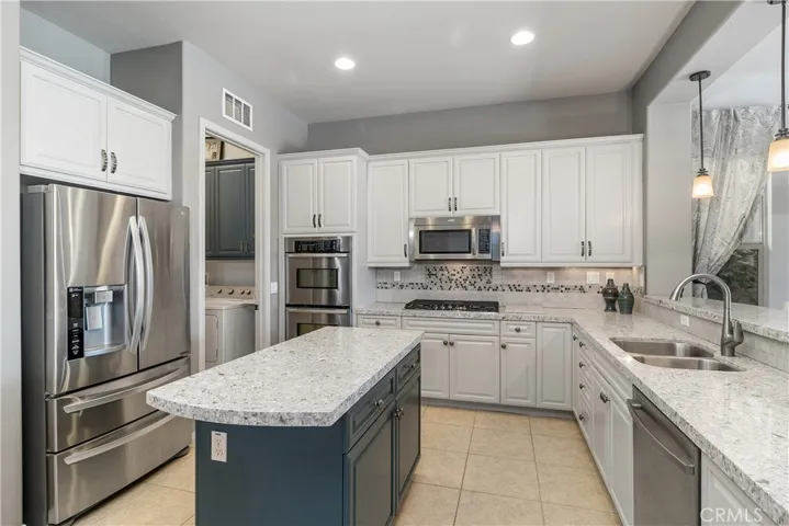 Updated Gourmet kitchen with large center island, quartz counters and custom backsplash.