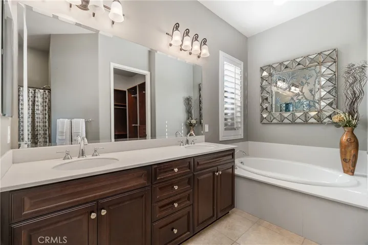 Primary bathroom with dual vanities, lots of cabinets, soaking tub, separate lavatory room. Additionally you have a huge walk in closet customized to maximize your storage.