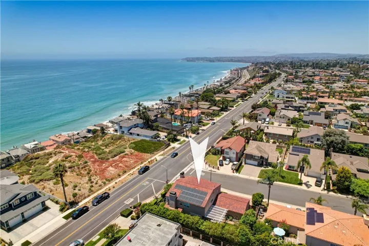 Drone view of the ocean, house and solar panels.