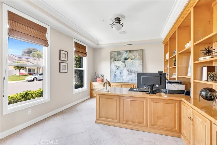 The downstairs office is complete with a large built in desk, several cabinets for storage and a wall of bookcases.