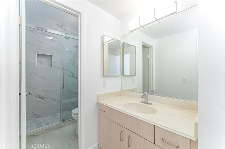 En suite bath two with all new walk in shower with frameless glass door, dual shower heads, new toilet and fixtures