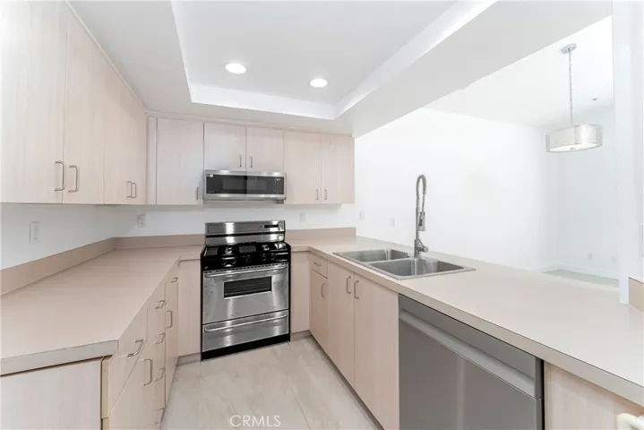 Renovated kitchen with new stainless steel gas range, microwave hood and dishwasher with large pantry