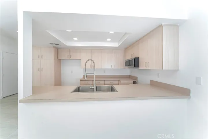 Renovated kitchen with new stainless steel gas range, microwave hood and dishwasher with large pantry