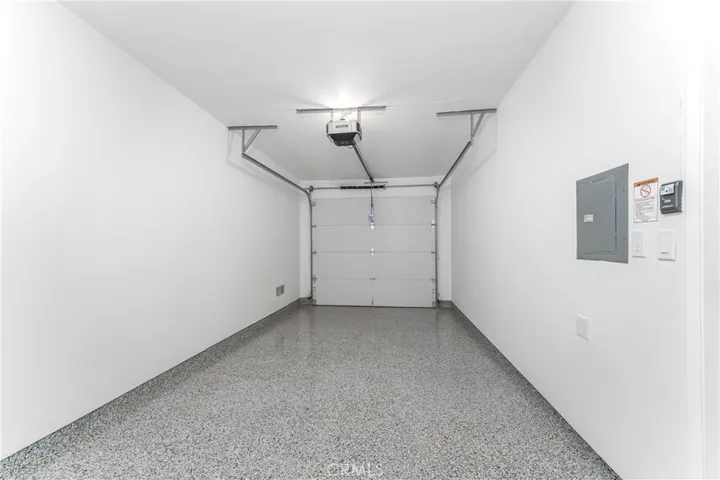 Fully finished garage with epoxy floor, steel back insulated garage door with MyQ wifi remote opener, and 220 Volt receptacle