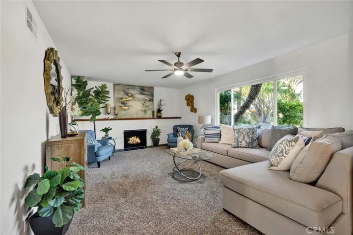  Large Formal Living Room that Showcases a Gas Wood-Burning Fireplace with Wall-to-Wall Mantel and Hearth