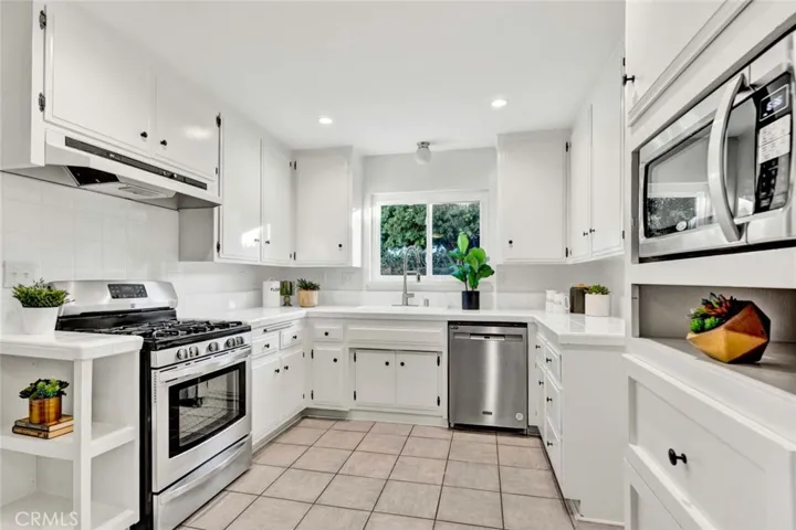 s Open to the Sunlit All White Kitchen with Stainless Appliances (Gas Range, Dishwasher, Microwave, a Spacious Pantry