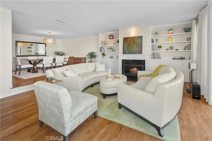 Living room and Dining room connect for entertaining flow. Note the Beautiful cabinetry and cozy fireplace along the side wall.