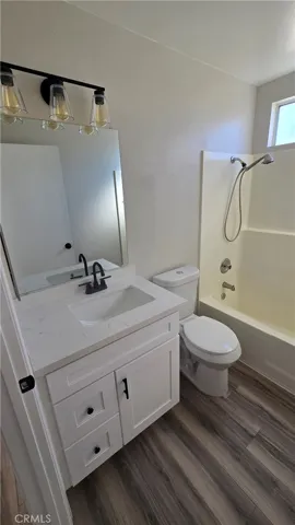 Hall Bathroom with new vanity, light fixtures and toilet and flooring.