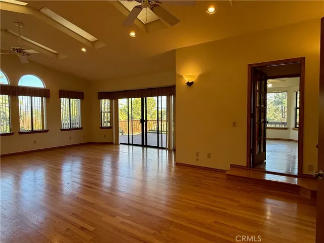 Multipurpose room with cathedral ceilings, skylights, fans and so much natural light! Doorway ahead to the breakfast nook. Large patio doors lead to the wrap around porch