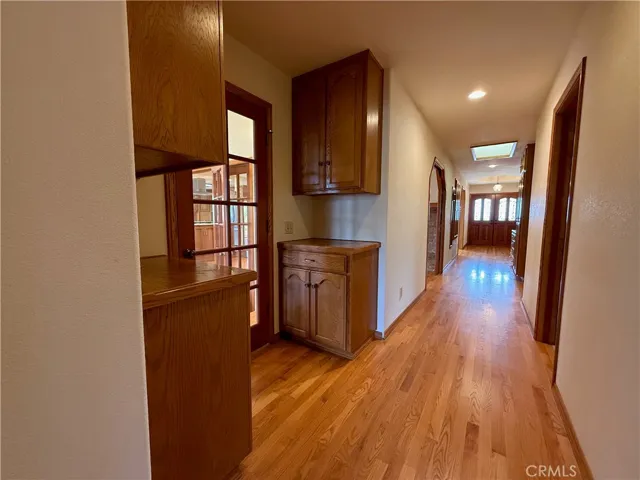 So much storage! Hallway from primary bedroom suite to front door. Door to the left leads to multi-purpose room.