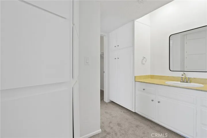 hallway with lots of extra storage space leads to the large separate walk-in closet and the bedroom